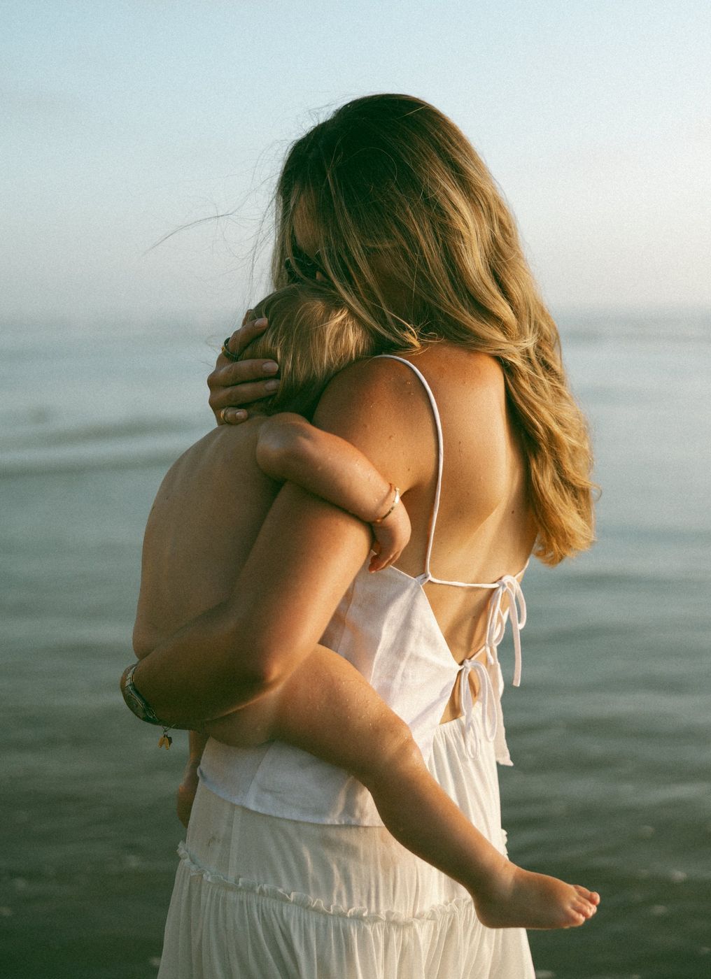 Alexa holding her child close by the ocean